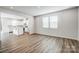 Sunlit open floor plan living room with sleek wood floors and modern design, leading into a white kitchen at 2260 Hedgecliff Rd # 163, Kannapolis, NC 28025