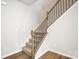 Carpeted staircase with a light wood banister and black metal spindles at 2280 Hedgecliff Rd, Kannapolis, NC 28025