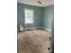 A view of a quiet bedroom with light blue walls, carpet, and window allowing natural light at 2404 Booker Ave, Charlotte, NC 28216