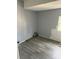 A view of an empty room with grey walls, wood look flooring, and window allowing natural light at 2404 Booker Ave, Charlotte, NC 28216