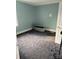 A view of a quiet bedroom with light blue walls, neutral carpet, and window allowing natural light at 2404 Booker Ave, Charlotte, NC 28216
