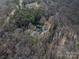 Aerial view of home nestled amongst mature trees with detached garage and garden at 246 Jerry Crump Rd, Lincolnton, NC 28092