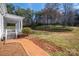 Beautiful backyard showcasing a brick pathway leading to a covered porch and a serene, tree-lined landscape at 246 Jerry Crump Rd, Lincolnton, NC 28092