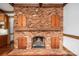 Unique brick fireplace with wood beam mantel, brick hearth, and decorative wooden doors at 246 Jerry Crump Rd, Lincolnton, NC 28092