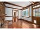 Cozy living room features a brick fireplace, wood beam accents, hardwood floors, and a large window at 246 Jerry Crump Rd, Lincolnton, NC 28092