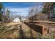Large yard view showcases retaining wall with mature landscaping between the home and detached garage at 246 Jerry Crump Rd, Lincolnton, NC 28092