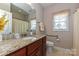 Bathroom featuring granite countertop, modern faucet, and soft window treatments at 258 Lagoda Dr, Locust, NC 28097