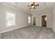 Expansive bedroom featuring neutral colors, a tray ceiling, and natural light from multiple windows at 258 Lagoda Dr, Locust, NC 28097