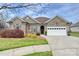 Charming brick home with a manicured lawn, tidy landscaping and a two-car garage at 258 Lagoda Dr, Locust, NC 28097