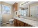 Well-lit bathroom with a single sink vanity, window, neutral tile and a full-sized mirror at 2745 River Meadows Ct, Lincolnton, NC 28092