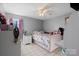 Bright bedroom with stylish floral bedding, pink accents, and a window with natural light at 2745 River Meadows Ct, Lincolnton, NC 28092