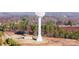 An aerial shot showcases a town's infrastructure, including a water tower, buildings, and green spaces surrounded by trees at 2853 W Zion Church Rd, Shelby, NC 28150