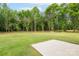 Large grassy backyard featuring a patio area and treeline at 2853 W Zion Church Rd, Shelby, NC 28150