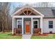 Close up of the home's charming craftsman-style front porch and orange front door at 2853 W Zion Church Rd, Shelby, NC 28150
