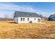 Back exterior of a white home with a dark roof and small patio with lawn at 2867 W Zion Church Rd, Shelby, NC 28150