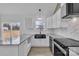 Bright kitchen featuring white cabinets, granite countertops, stainless appliances, and a farmhouse sink at 2867 W Zion Church Rd, Shelby, NC 28150