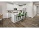 Modern kitchen featuring white cabinetry, an island with green chairs and stainless appliances at 3020 Finchborough Ct # 230, Charlotte, NC 28269