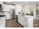 Bright kitchen with stainless steel appliances, white cabinetry, an island, and wood floors at 3020 Finchborough Ct # 230, Charlotte, NC 28269