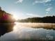Scenic lake view at sunrise, featuring a serene and picturesque natural setting with water reflection and morning fog at 3020 Finchborough Ct # 230, Charlotte, NC 28269