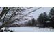 Snowy backyard featuring wooded scenery, small wooden structure, and metal fences at 3427 Joe Johnson Rd, Catawba, NC 28609