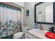 Cozy bathroom with a floral shower curtain, mirror, and vanity with storage space at 3427 Joe Johnson Rd, Catawba, NC 28609