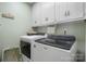 Well-lit laundry room with overhead cabinets and modern washer and dryer units at 3427 Joe Johnson Rd, Catawba, NC 28609