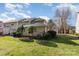 Well-maintained backyard with a lush lawn, manicured shrubs, and a view of the home's beige siding and dark roof at 3610 Melrose Cottage Dr, Matthews, NC 28105