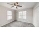 Bright bedroom features neutral walls, carpet, and a ceiling fan, complemented by two windows at 3610 Melrose Cottage Dr, Matthews, NC 28105