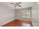 Cozy bedroom featuring hardwood floors, a modern ceiling fan, and a bright window at 3610 Melrose Cottage Dr, Matthews, NC 28105