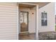 Inviting entrance features a cream-colored door and sidelight, accented by a stylish light fixture and wind chime at 3610 Melrose Cottage Dr, Matthews, NC 28105