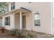 Charming front entrance with covered porch, features a beige exterior, a lantern-style light, and a decorative window at 3610 Melrose Cottage Dr, Matthews, NC 28105