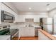 Well-lit kitchen with white cabinets, stainless steel appliances, and ample counter space at 3610 Melrose Cottage Dr, Matthews, NC 28105