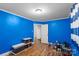 Bedroom with vibrant blue walls, wood-look floors, and a view into another room at 41 Fleetwood Sw Dr # 44, Concord, NC 28027
