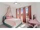 Bright bedroom featuring large windows, a ceiling fan, and a charming canopy over the bed at 416 Clemson Tree Ln, Lake Wylie, SC 29710