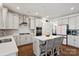 Open-concept kitchen boasts stainless appliances, white cabinets, quartz counters, and an island with seating at 416 Clemson Tree Ln, Lake Wylie, SC 29710
