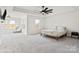 Airy main bedroom with neutral carpet, a ceiling fan, and an adjoining sitting area at 416 Clemson Tree Ln, Lake Wylie, SC 29710