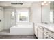Bright bathroom with a glass enclosed shower, soaking tub, and vanity with white marble countertop at 4688 Glen Stripe Dr # Cal0069, Indian Trail, NC 28079