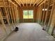 Unfinished bedroom with natural light, showcasing the framing and window placement at 4688 Glen Stripe Dr # Cal0069, Indian Trail, NC 28079