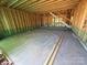 The unfinished garage's studs and concrete floor providing a blank slate for a workshop or parking at 4688 Glen Stripe Dr # Cal0069, Indian Trail, NC 28079