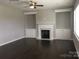 Cozy living room with a fireplace, built-in cabinets, and dark hardwood floors at 4688 Glen Stripe Dr # Cal0069, Indian Trail, NC 28079