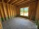 Empty room under construction with unfinished concrete floor and wood framing, viewed from corner at 4688 Glen Stripe Dr # Cal0069, Indian Trail, NC 28079