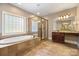 Bright bathroom featuring a soaking tub, glass enclosed shower, double vanity, and neutral tile at 472 Barber Loop, Mooresville, NC 28117
