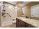 Bathroom with a walk in shower and granite sink with wooden cabinets and a large mirror at 472 Barber Loop, Mooresville, NC 28117