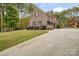 Charming brick home with a long driveway, landscaped yard, and three-car garage at 472 Barber Loop, Mooresville, NC 28117