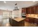 An open kitchen with granite countertops, wood cabinets, stainless appliances, and a central island at 472 Barber Loop, Mooresville, NC 28117