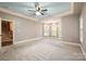 Expansive main bedroom featuring a tray ceiling, carpet, and a sitting area near arch windows at 472 Barber Loop, Mooresville, NC 28117