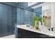 Modern bathroom featuring blue tiled walls, double vanity, walk-in shower, and decorative accents at 6005 Valehaven Pl # 0049, Charlotte, NC 28269