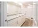 Well-lit bathroom features double vanity with white cabinets, marble countertops and a shower at 620 Smith St # B, Mooresville, NC 28115