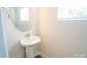 Well-lit powder room features a pedestal sink and an oval mirror at 620 Smith St # B, Mooresville, NC 28115