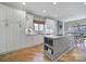 Bright kitchen with hardwood floors, island with grey base, stone countertop and an adjacent dining table at 726 Amberly Xing, Fort Mill, SC 29708